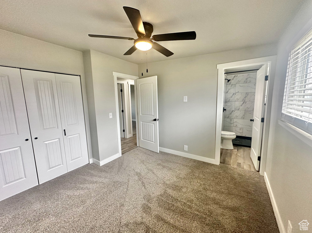 Unfurnished bedroom featuring ensuite bath, a closet, ceiling fan, and light colored carpet
