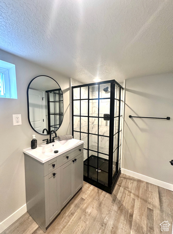 Bathroom featuring hardwood / wood-style floors, vanity, and a textured ceiling