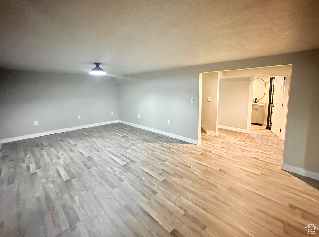 Unfurnished room featuring light hardwood / wood-style flooring and a textured ceiling