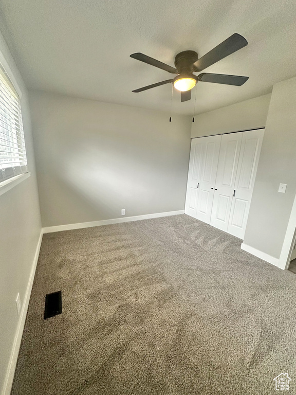 Unfurnished bedroom with carpet floors, ceiling fan, and a closet