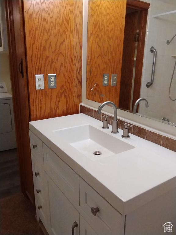 Bathroom featuring washer / dryer and vanity with extensive cabinet space