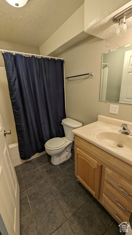 Full bathroom with oversized vanity, a textured ceiling, toilet, tile flooring, and shower / bath combination with curtain