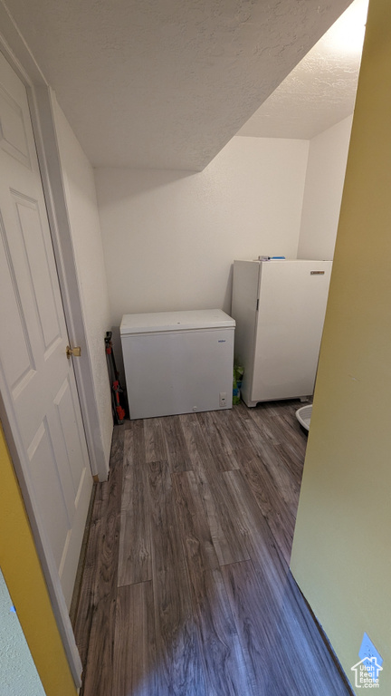 Laundry area with dark hardwood / wood-style floors