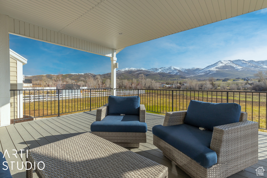 Wooden deck with a mountain view, an outdoor living space, and a yard
