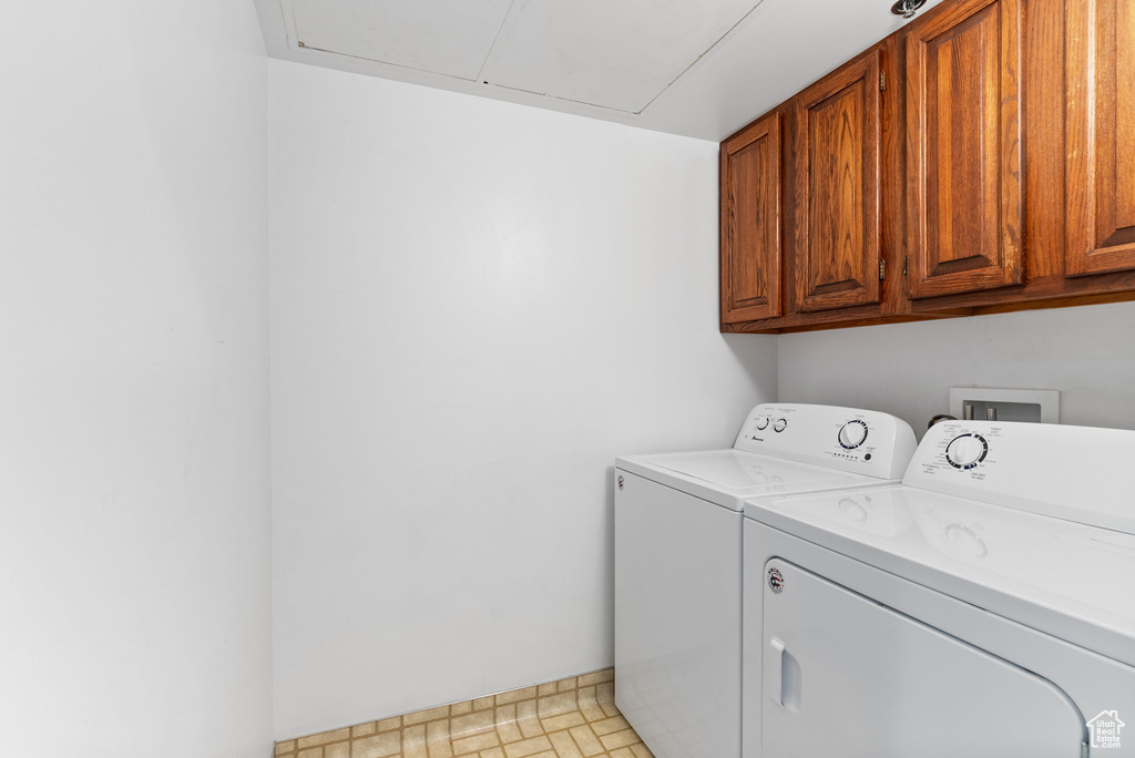 Laundry area with cabinets, hookup for a washing machine, separate washer and dryer, and light tile floors