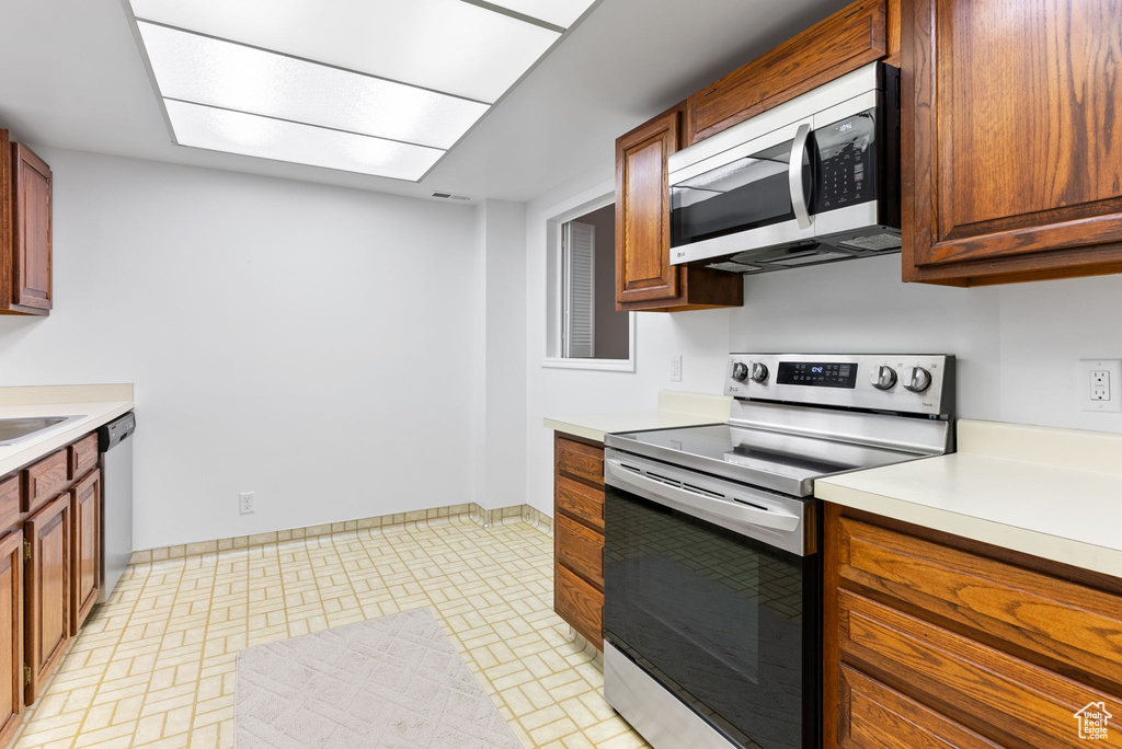 Kitchen with sink, light tile floors, and stainless steel appliances