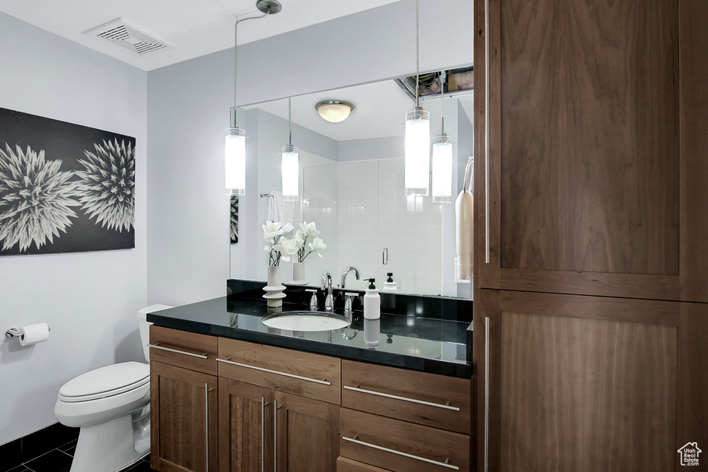 Bathroom featuring vanity, toilet, plenty of natural light, and tile flooring
