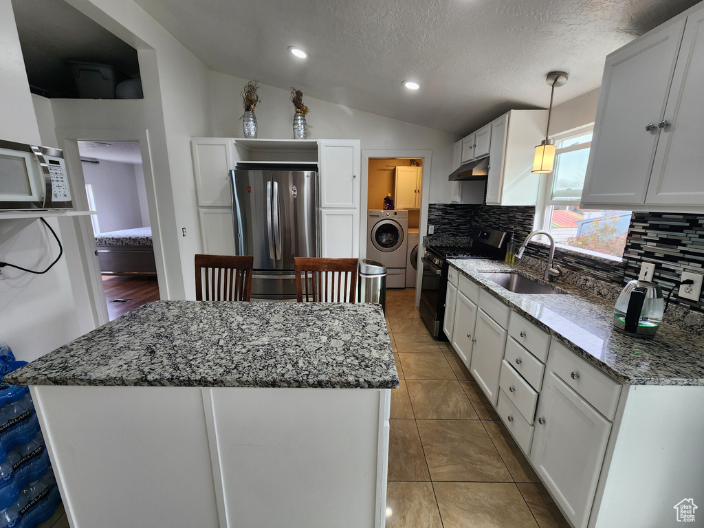 Kitchen featuring tasteful backsplash, sink, stainless steel appliances, and white cabinets
