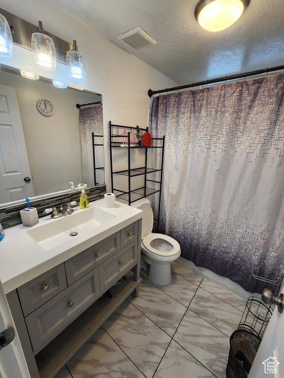 Bathroom with tile floors, oversized vanity, and toilet