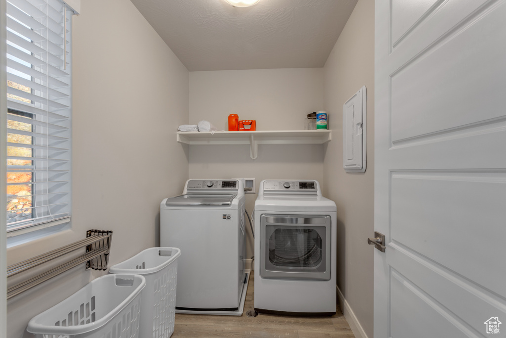Clothes washing area featuring washer hookup, separate washer and dryer, and light wood-type flooring