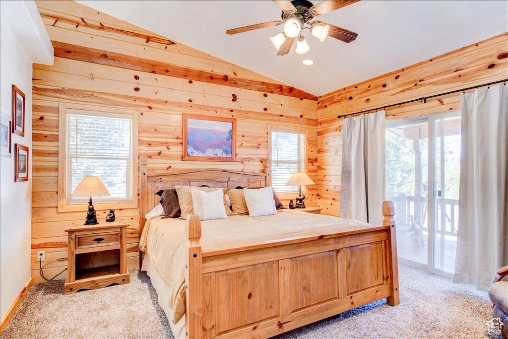 Carpeted bedroom featuring lofted ceiling, ceiling fan, multiple windows, and access to exterior