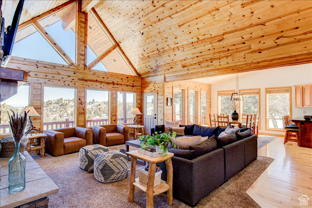 Living room with a wealth of natural light, light hardwood / wood-style flooring, wood ceiling, and high vaulted ceiling