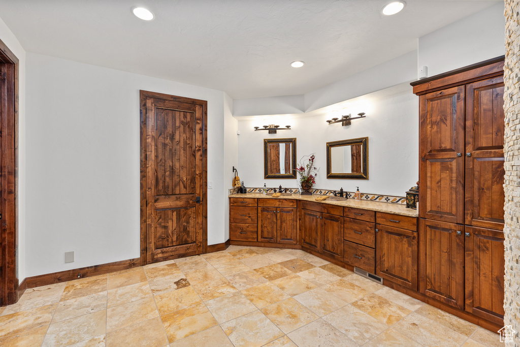 Bathroom featuring tile floors and dual bowl vanity
