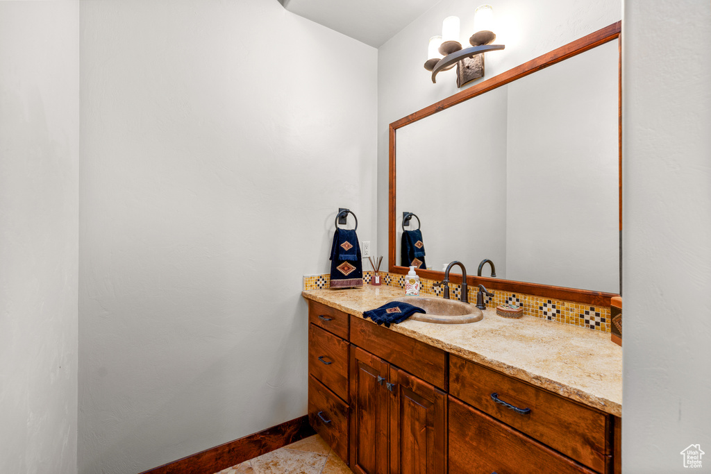 Bathroom featuring vanity, a chandelier, and tile floors