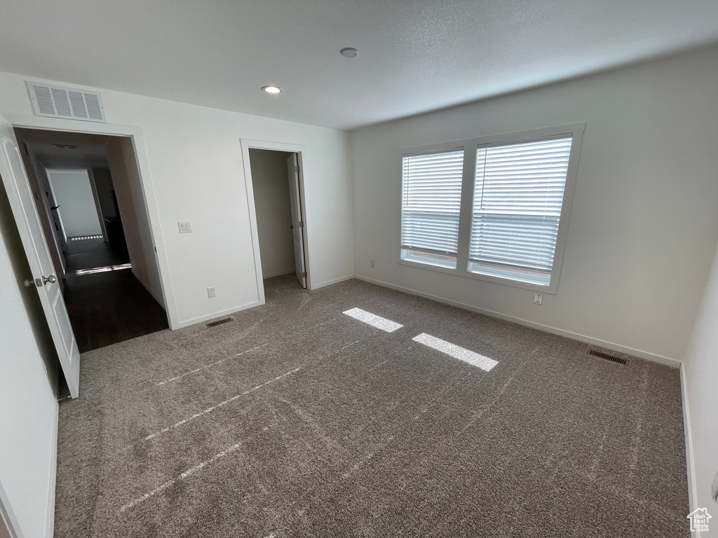 Unfurnished bedroom with multiple windows, a closet, and carpet flooring