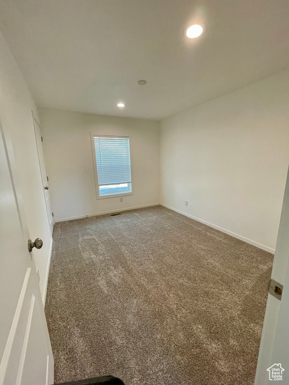 Spare room featuring dark carpet