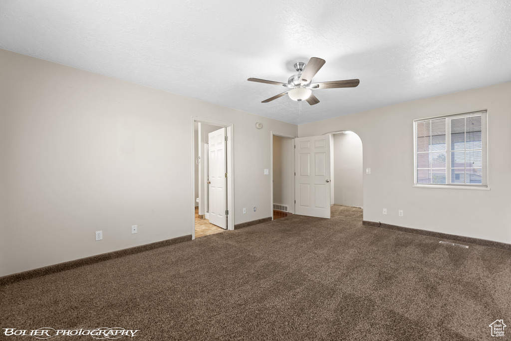 Unfurnished bedroom featuring ensuite bathroom, ceiling fan, and carpet