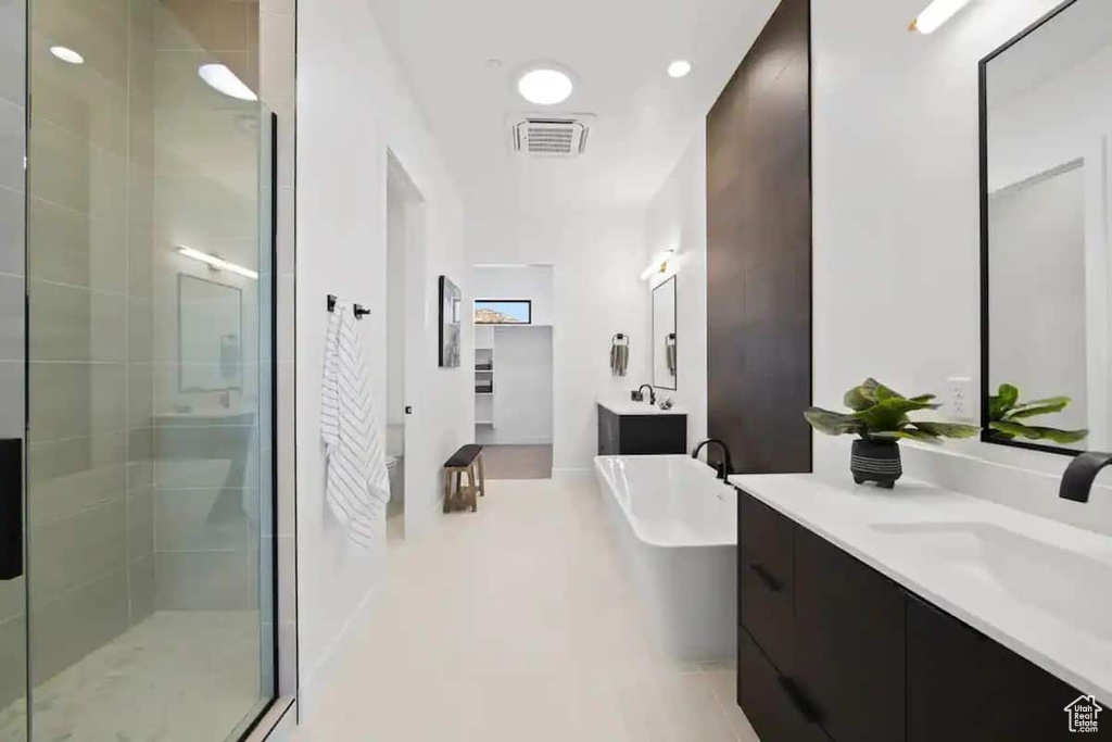 Bathroom featuring a shower with shower door and oversized vanity