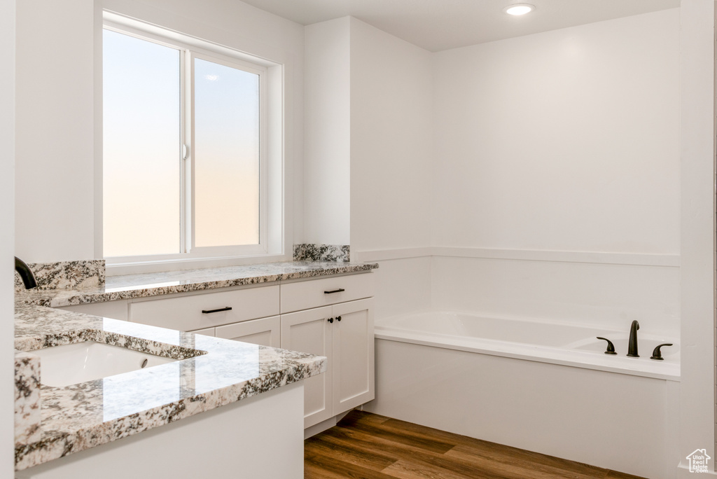 Bathroom featuring a wealth of natural light, a bathtub, and vanity