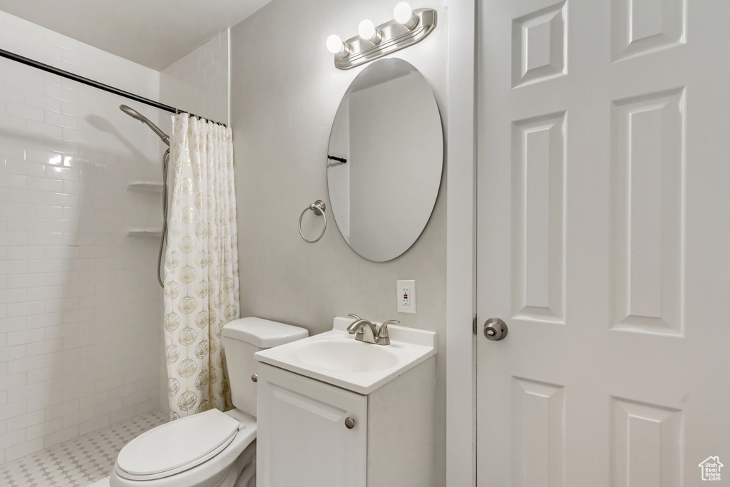 Bathroom with a shower with curtain, large vanity, and toilet