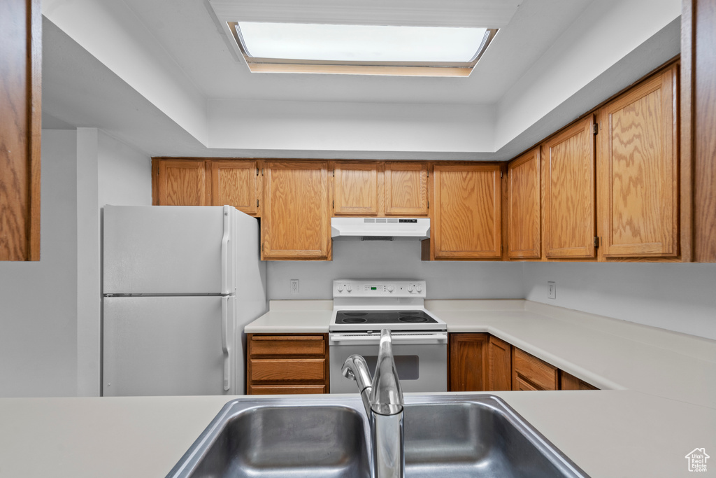 Kitchen with white appliances and sink