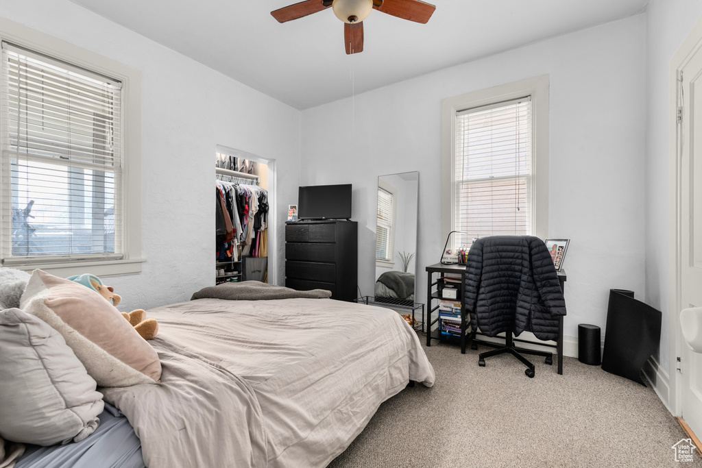 Bedroom featuring ceiling fan, light colored carpet, and a closet