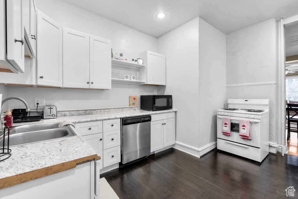 Kitchen featuring dark wood-type flooring, white cabinets, sink, dishwasher, and white range with gas stovetop