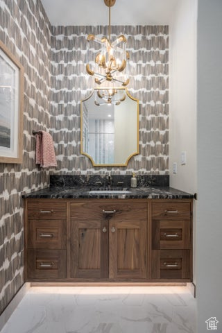 Bathroom featuring a notable chandelier and vanity