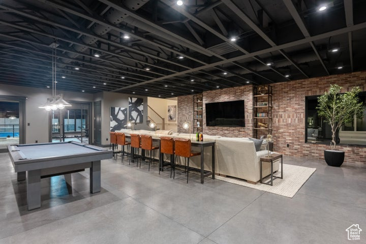 Rec room featuring brick wall, concrete flooring, and billiards