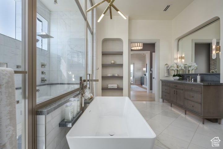 Bathroom with tile flooring, a notable chandelier, tile walls, and vanity