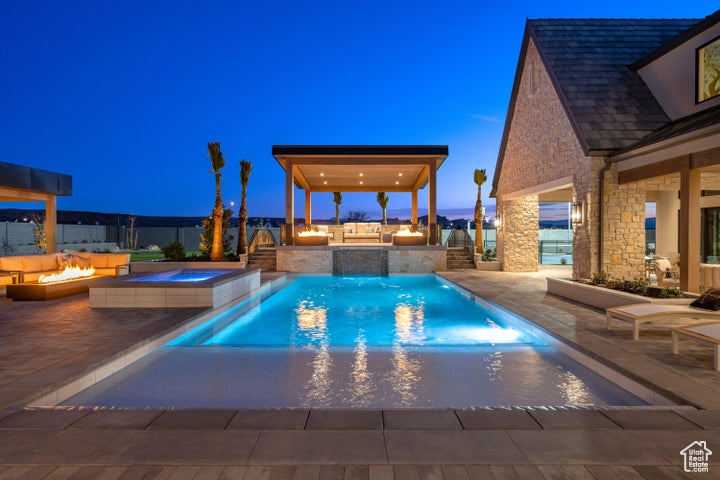 View of pool with a fire pit, a patio area, an in ground hot tub, and an outdoor kitchen