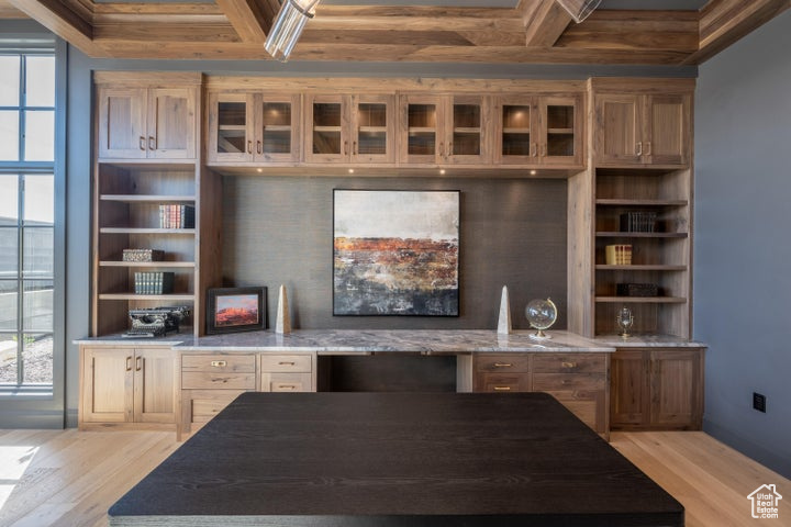 Kitchen featuring light wood-type flooring, light stone countertops, and plenty of natural light