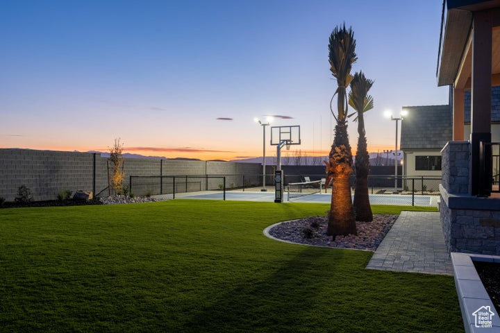 Yard at dusk featuring basketball hoop