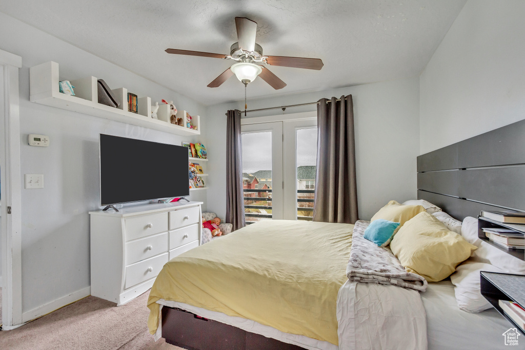 Bedroom featuring ceiling fan, access to outside, and light carpet