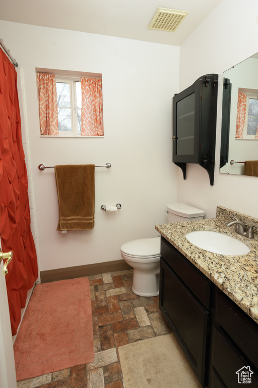 Bathroom featuring tile floors, oversized vanity, and toilet
