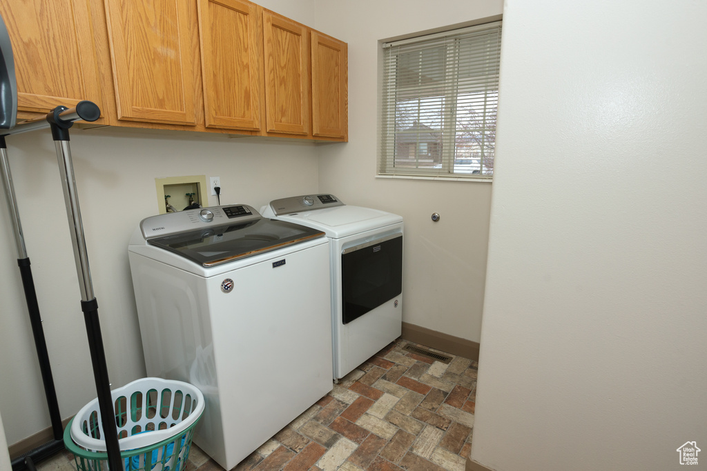 Laundry room featuring washer and dryer, cabinets, and washer hookup