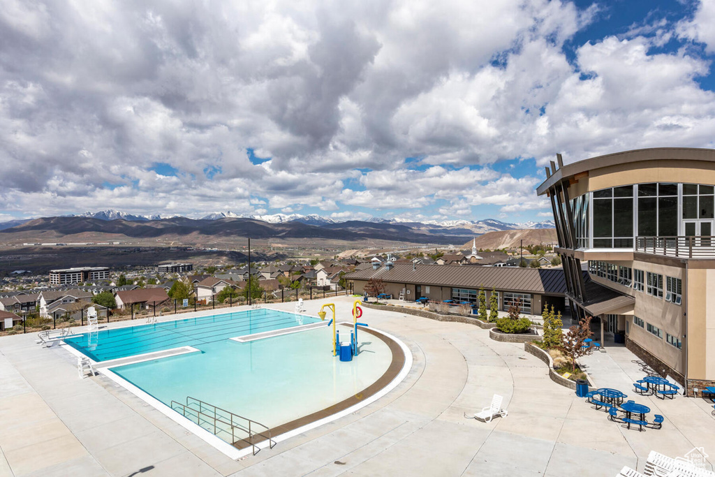 View of swimming pool with a mountain view and a diving board