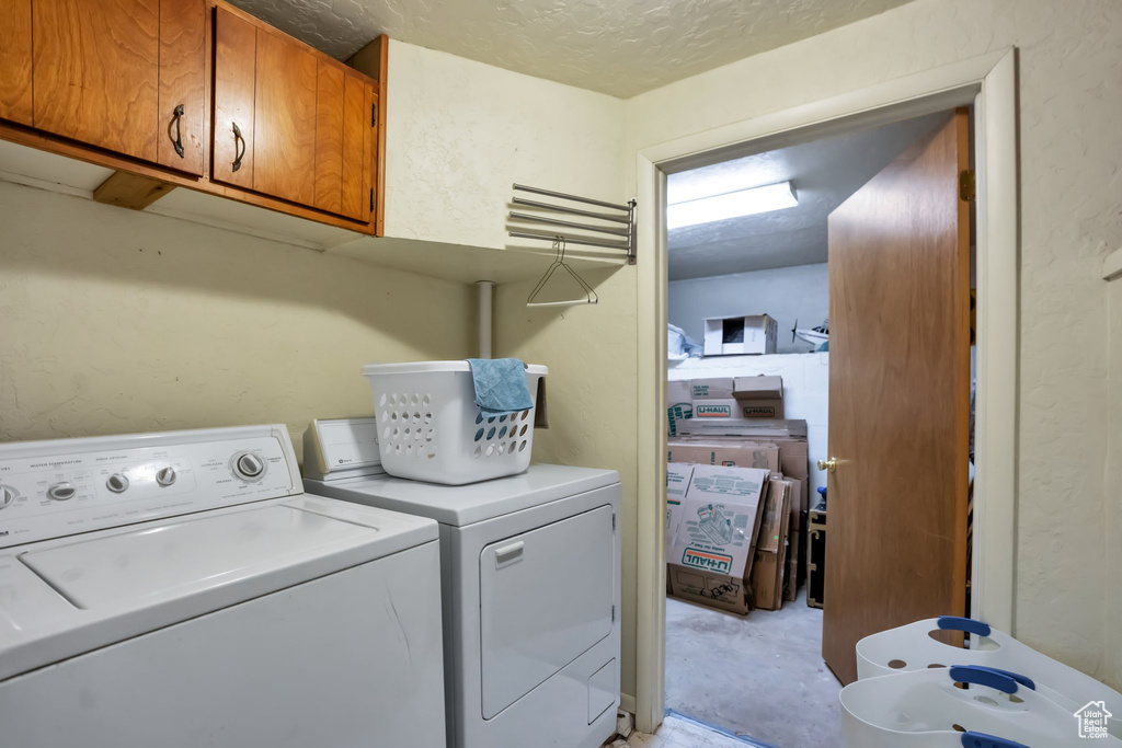 Washroom featuring cabinets and washer and dryer