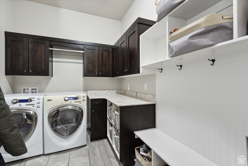 Laundry area featuring washer hookup, light tile floors, separate washer and dryer, and cabinets