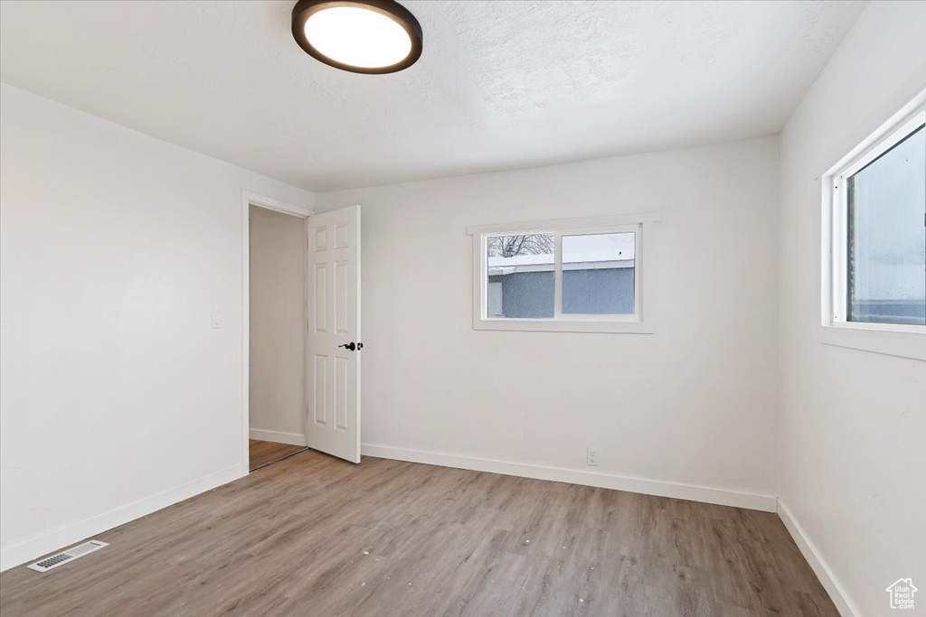 Spare room featuring a wealth of natural light and light hardwood / wood-style flooring