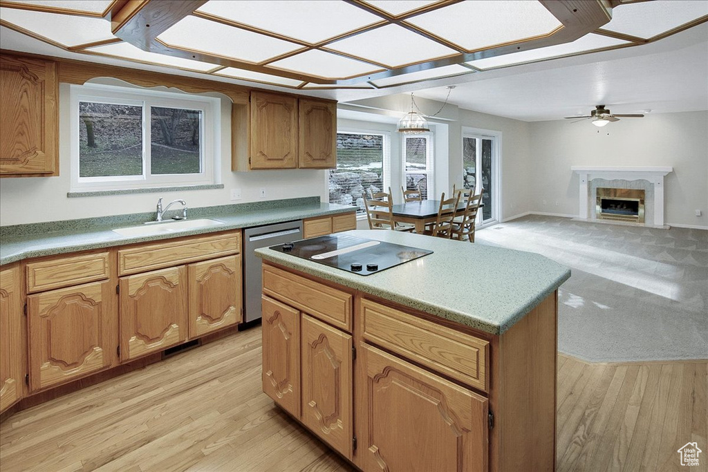 Kitchen featuring a center island, light hardwood / wood-style floors, a premium fireplace, sink, and dishwasher