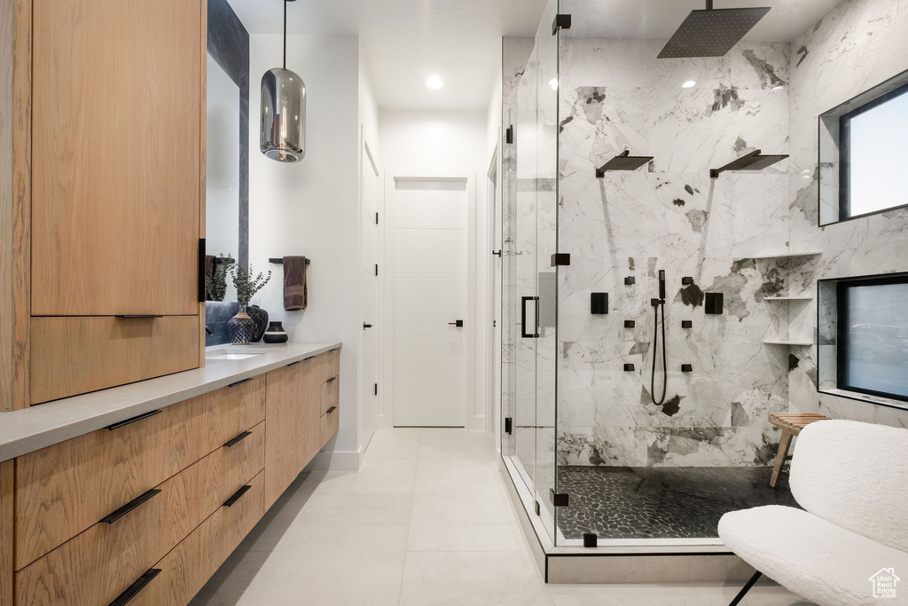 Bathroom featuring vanity, an enclosed shower, and tile floors