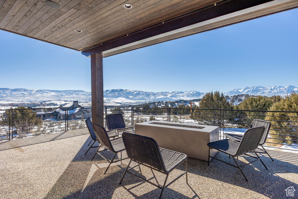 View of patio featuring an outdoor living space, a mountain view, and a balcony