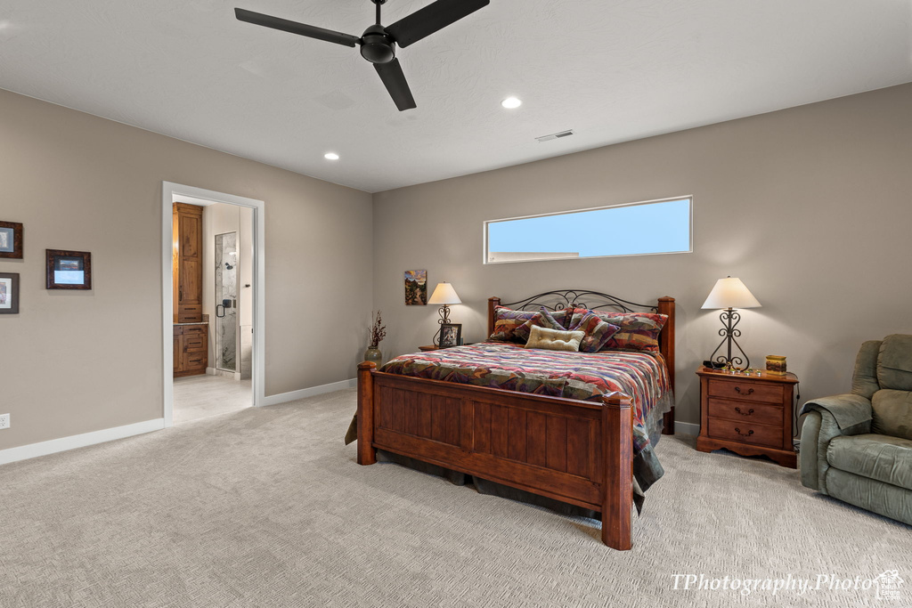 Carpeted bedroom with ceiling fan and ensuite bathroom