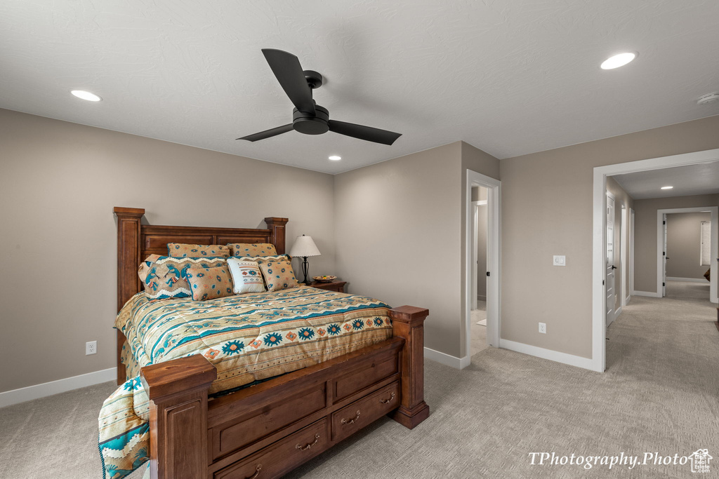 Carpeted bedroom with ceiling fan and ensuite bath