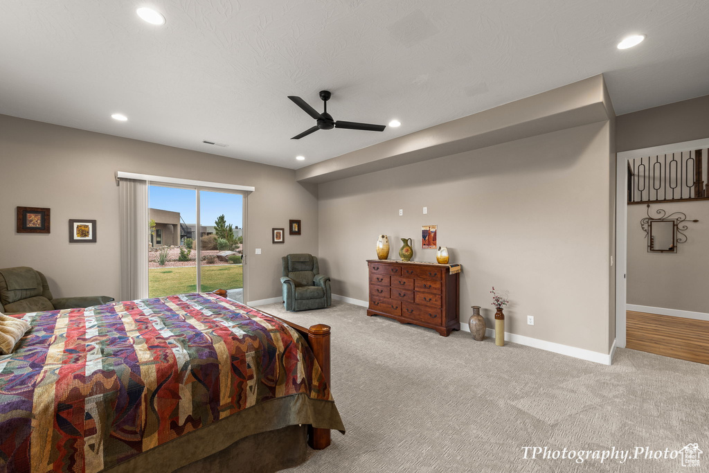 Bedroom with ceiling fan, light colored carpet, and access to exterior