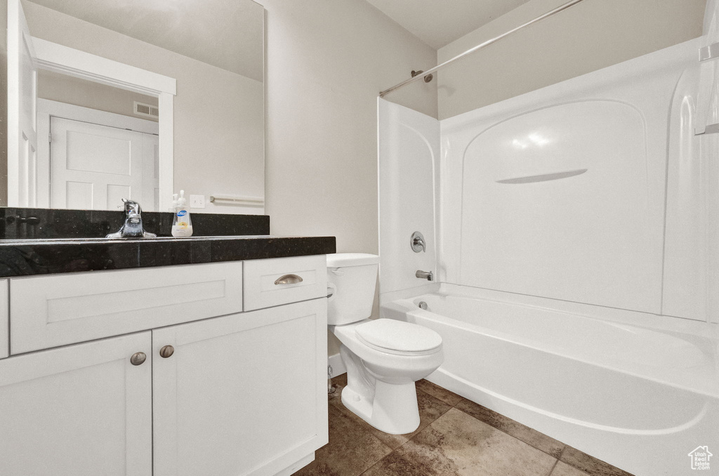 Full bathroom featuring vanity with extensive cabinet space, tile flooring, tub / shower combination, and toilet