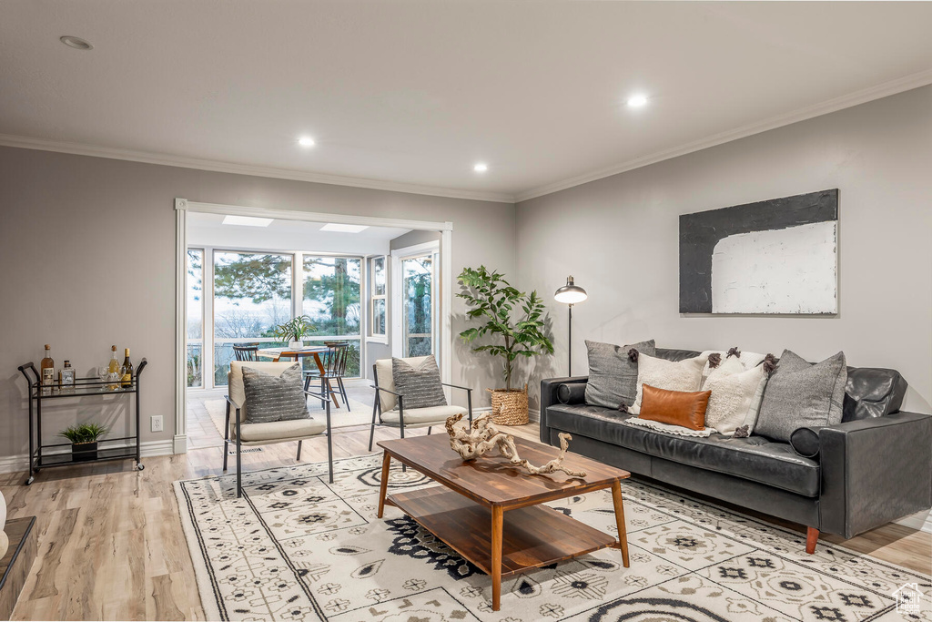 Living room featuring light hardwood / wood-style floors and ornamental molding