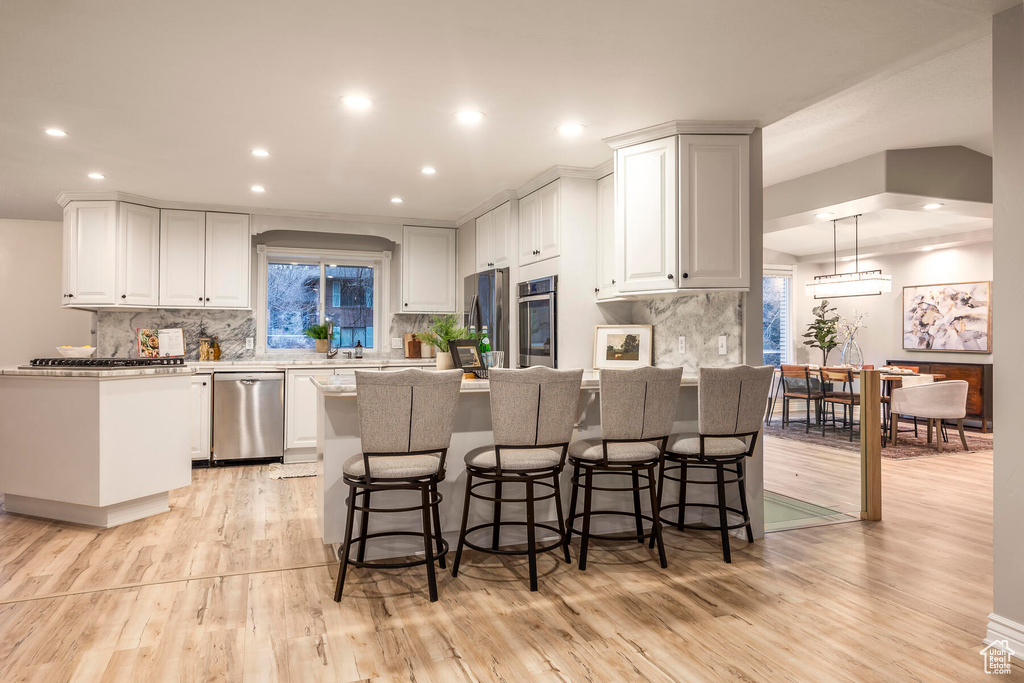 Kitchen featuring appliances with stainless steel finishes, light hardwood / wood-style floors, and white cabinets