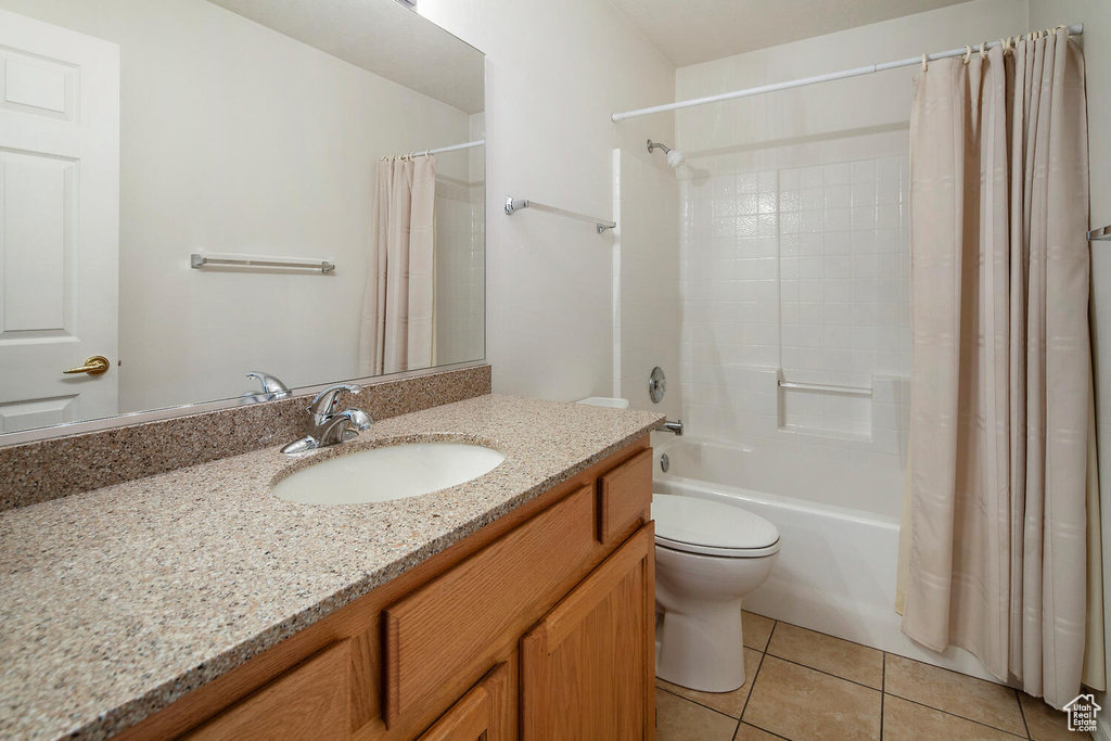 Full bathroom with shower / bathtub combination with curtain, large vanity, tile floors, and toilet